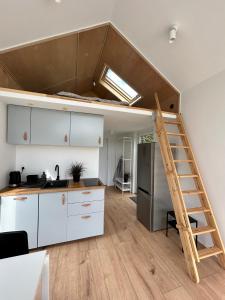 a kitchen with a loft bed in a room at Leśny Staw Stodoła in Gilwa +15 photos