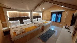 a large room with two beds and a window at Hotel Outlook - Pahalgam in Pahalgām +71 photos