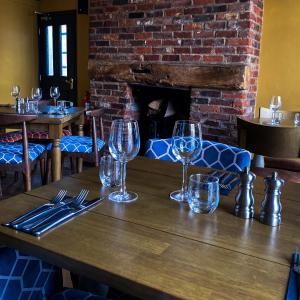 una mesa en un restaurante con copas de vino. en The Kings Head Inn, home of The Acle Steak en Acle