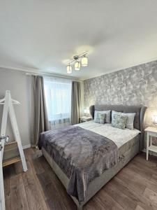 a bedroom with a large bed and a window at Ventspils Luxury Sunset View Apartments in Ventspils