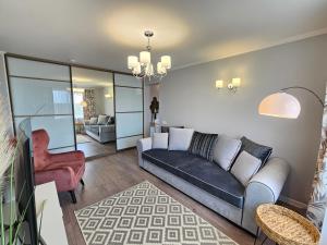 a living room with a couch and a chair at Ventspils Luxury Sunset View Apartments in Ventspils