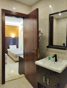 un bagno con lavandino, specchio e letto di Petra Town Check-Inn a Wadi Musa
