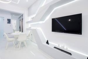 a white living room with a flat screen tv on the wall at Cozy two-bedroom apartment in Athens in Piraeus