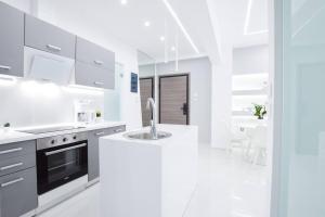 a white kitchen with a sink and a stove at Cozy two-bedroom apartment in Athens in Piraeus