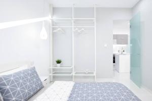 a white bedroom with a bed and a kitchen at Cozy two-bedroom apartment in Athens in Piraeus