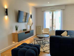 a living room with a blue couch and a tv at Le 21 Favre, Hyper centre, 70 m², 2 chambres in Annecy