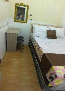 a bedroom with a bed and a table and a mirror at Hostel 24 in Bangkok