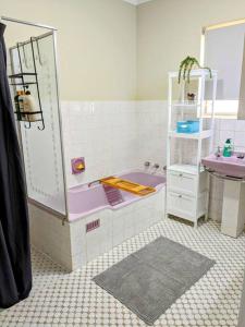a bathroom with a purple tub and a sink at Holli-daze on Coast Moonta Bay in Port Moonta