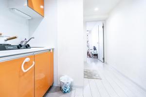 cocina con armario de color naranja y pasillo en Shinjuku Ryokan Retreat丶Local Tokyo Experience & Short Trips Hub丶walk to Higahsi Shinjuku station LoE2, en Tokio