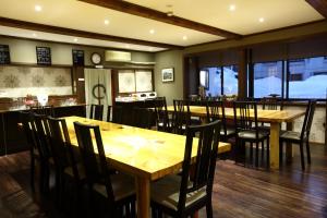 a dining room with wooden tables and chairs at Snowlines Lodge Hakuba in Hakuba