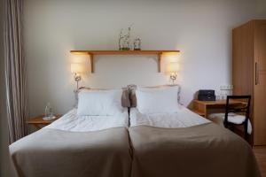 ein großes Bett in einem Zimmer mit zwei Kissen in der Unterkunft Kiviks Hotell in Kivik