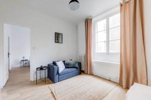 sala de estar con sofá azul y ventana en Le White Cozy - Lyon - Croix Rousse en Lyon