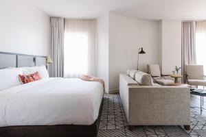 a hotel room with a bed and a couch at The Alida, Savannah, a Tribute Portfolio Hotel in Savannah
