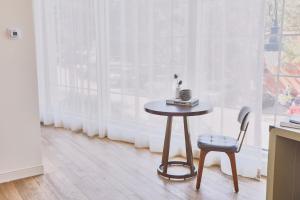 a table and a chair in a room with a window at The Alida, Savannah, a Tribute Portfolio Hotel in Savannah
