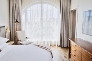 a bedroom with a white bed and a window at The Alida, Savannah, a Tribute Portfolio Hotel in Savannah