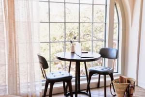 a table and chairs in front of a window at The Alida, Savannah, a Tribute Portfolio Hotel in Savannah