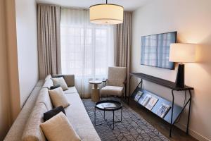 a living room with a couch and a table at The Alida, Savannah, a Tribute Portfolio Hotel in Savannah