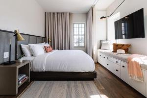 Un dormitorio con una gran cama blanca y una ventana en The Alida, Savannah, a Tribute Portfolio Hotel en Savannah