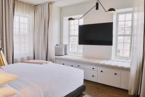 a bedroom with a bed and a flat screen tv at The Alida, Savannah, a Tribute Portfolio Hotel in Savannah