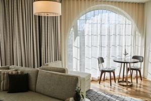 a living room with a couch and a table at The Alida, Savannah, a Tribute Portfolio Hotel in Savannah
