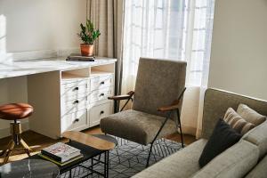 a living room with a couch and a chair at The Alida, Savannah, a Tribute Portfolio Hotel in Savannah
