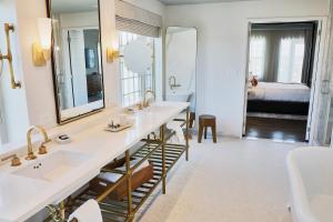 a bathroom with two sinks and a large mirror at The Alida, Savannah, a Tribute Portfolio Hotel in Savannah