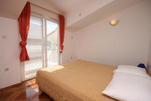 1 dormitorio con cama y ventana grande en Apartments and rooms by the sea Pag - 6311 en Pag