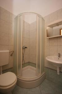 a bathroom with a shower and a toilet and a sink at Apartments and rooms by the sea Pag - 6311 in Pag