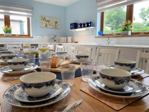 a kitchen with a table with bowls and plates on it at Pass the Keys Spectacular 7BR House Hot Tub and Gardens in Gretna in Gretna Green
