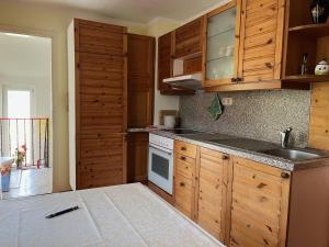 a kitchen with wooden cabinets and a sink at Familienfreundliche Ferienwohnung Kaltenleitner nahe Attersee für 5 Personen mit zwei Schlafzimmern in Weissenkirchen im Attergau