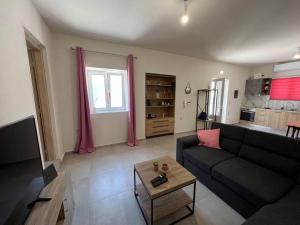 ein Wohnzimmer mit Sofa und Tisch in der Unterkunft Modern Stylist House for Friends in Iraklio