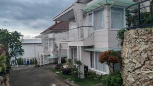 a large white building with a balcony at In Villa Garden Resort in Batu