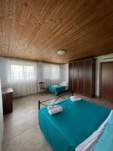 een slaapkamer met een blauw bed in een kamer bij Villa Garibaldina in Treglio