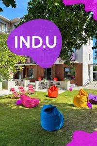 a group of colored chairs sitting in the grass at IND.U Apartamenty in Kołobrzeg