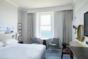 a hotel room with a bed and a table and a window at Bournemouth Highcliff Marriott Hotel in Bournemouth