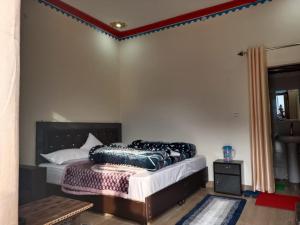 a bedroom with a bed with a black headboard at King of Himalaya Homestay in Sari