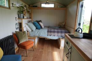 um pequeno quarto com uma cama numa pequena casa em Steam and Stars Luxury Glamping em Williton