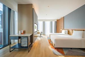 上海市にあるEVEN Hotels Shanghai Expo, an IHG Hotelのベッドとテーブルが備わるホテルルームです。