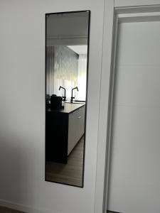espejo que refleja una cocina con fregadero y encimera en Onix, en Hunedoara