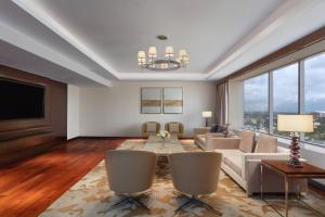 a living room with a couch and a table at Kochi Marriott Hotel in Cochin