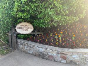 um sinal em frente a um jardim com flores em Bridge Farm Guesthouse rooms em Bristol