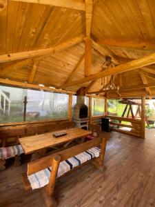 a large wooden room with a table and a fireplace at Escapadă la munte in Malaia in Malaia