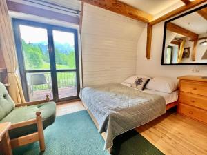 Habitación pequeña con cama y ventana en Villa Tatrydom, en Zakopane