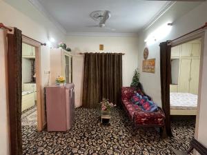 a living room with a couch and a refrigerator at A to Z Guest House in Hyderabad