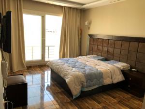 una camera con un grande letto e una grande finestra di Senior chalet in Haciendabay for rent a El Alamein