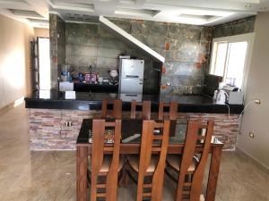 una cucina con tavolo, sedie e frigorifero di Senior chalet in Haciendabay for rent a El Alamein