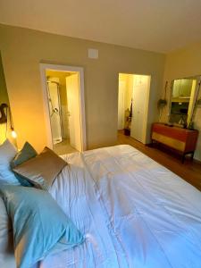 uma grande cama branca com almofadas num quarto em Brunico 20 em Brunico