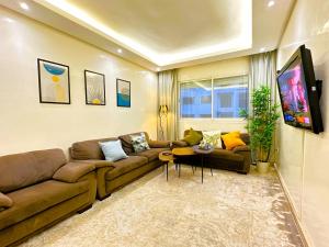 sala de estar con sofá y TV en Cosy and greeny flat near oasis train and tramway en Casablanca