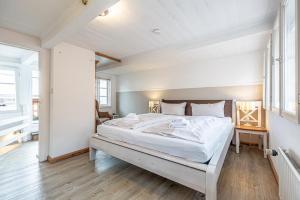 a bedroom with a large white bed in a room at fewo1846 - Kaete-Lassen-Huus - uriges Häuschen auf 3 Ebenen mit Dachterrasse am Hafen in Flensburg