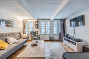 ein Wohnzimmer mit einem Sofa und einem TV in der Unterkunft fewo1846 - Kaete-Lassen-Huus - uriges Häuschen auf 3 Ebenen mit Dachterrasse am Hafen in Flensburg
